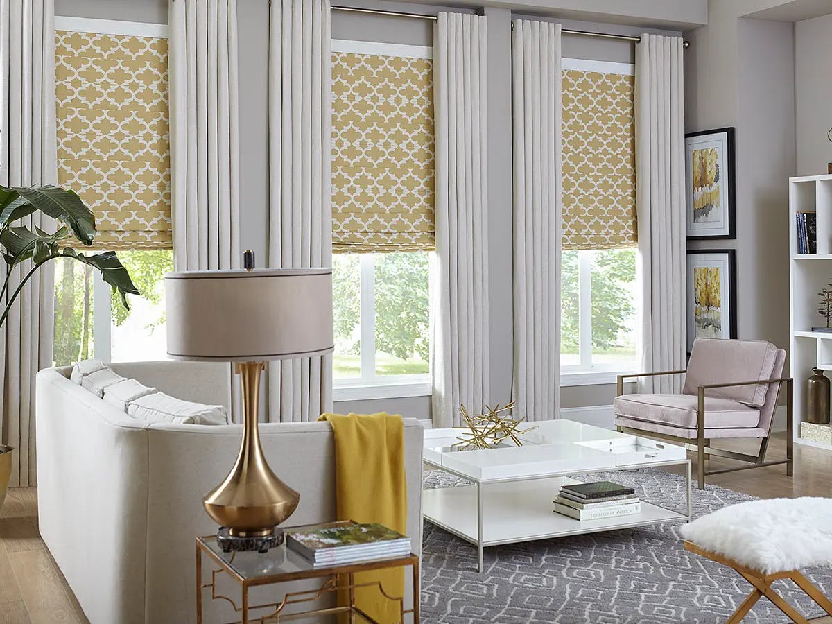 Living room with large windows with patterned roman shades.