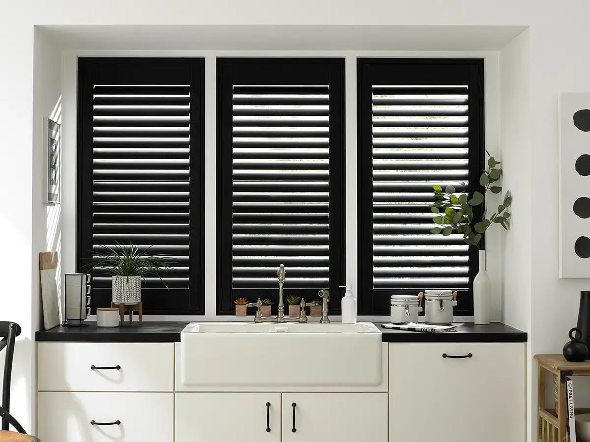 Room with black shutters and a sink.