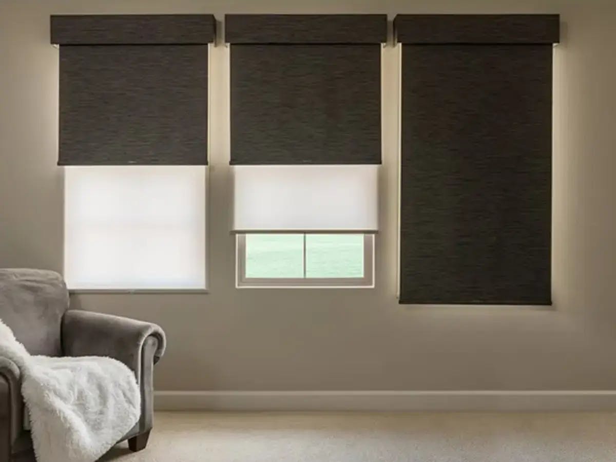 Dual-layered roller shades in a neutral-toned living room.