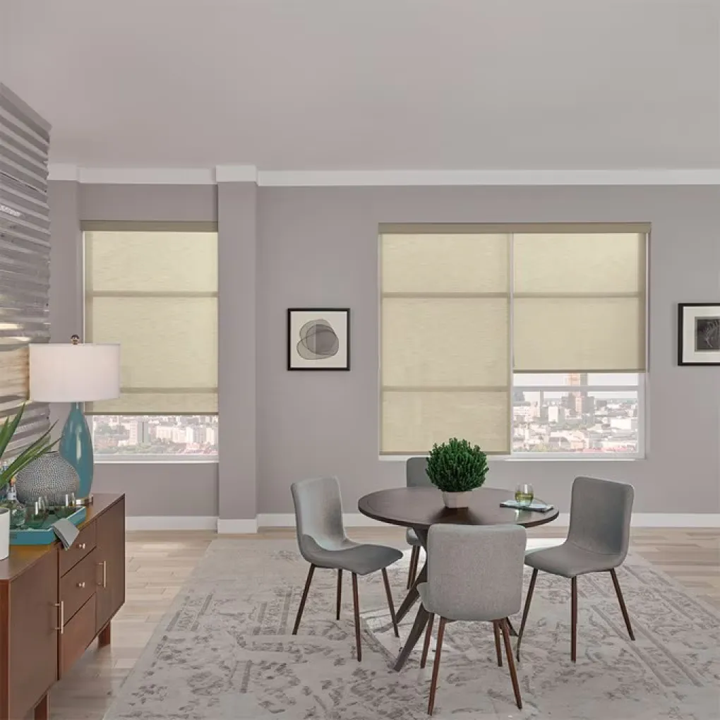 Dining room with mauve walls and cream roller shades on the windows. The dining table is dark wood with gray seats. There’s a patterned rug.