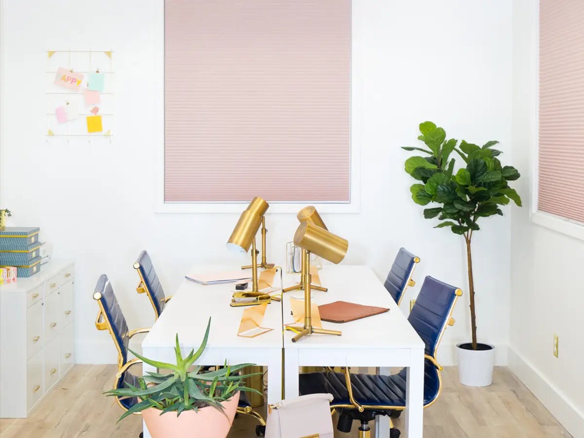 Bright office space with pink cellular shades.