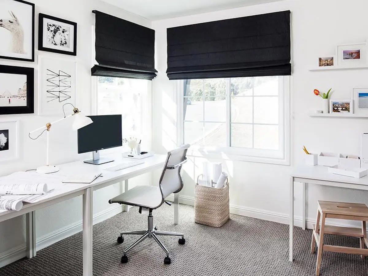 White office space with black roman shades.