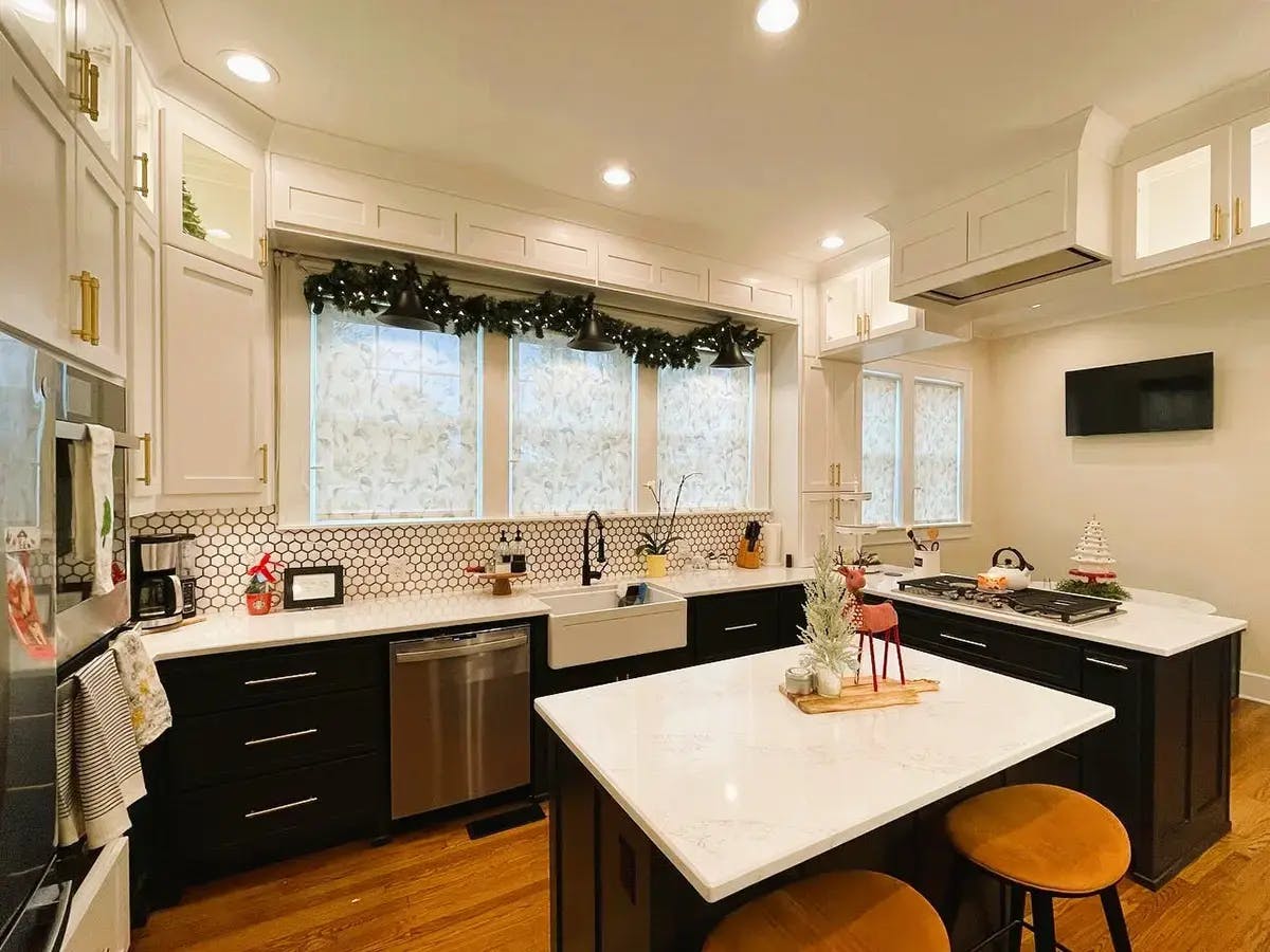 A modern kitchen space featuring roller shades and Christmas decorations.