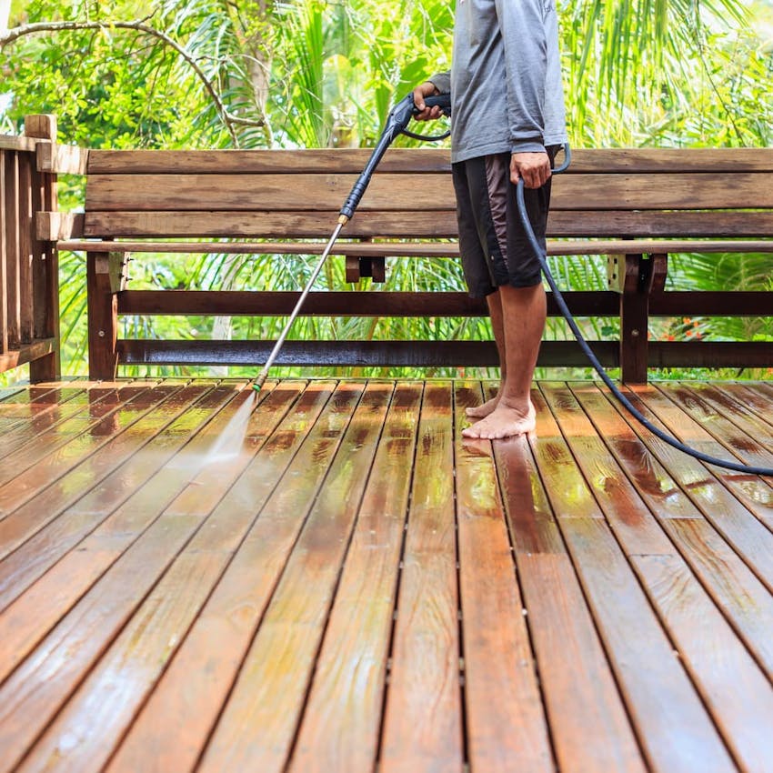 man power washing deck to prepare for outdoor party