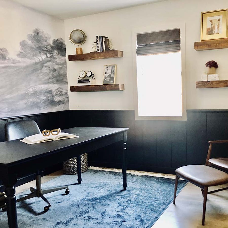 home office with scenic valley wallpaper, wood accents and black board and batten trim on the lower half of the walls.