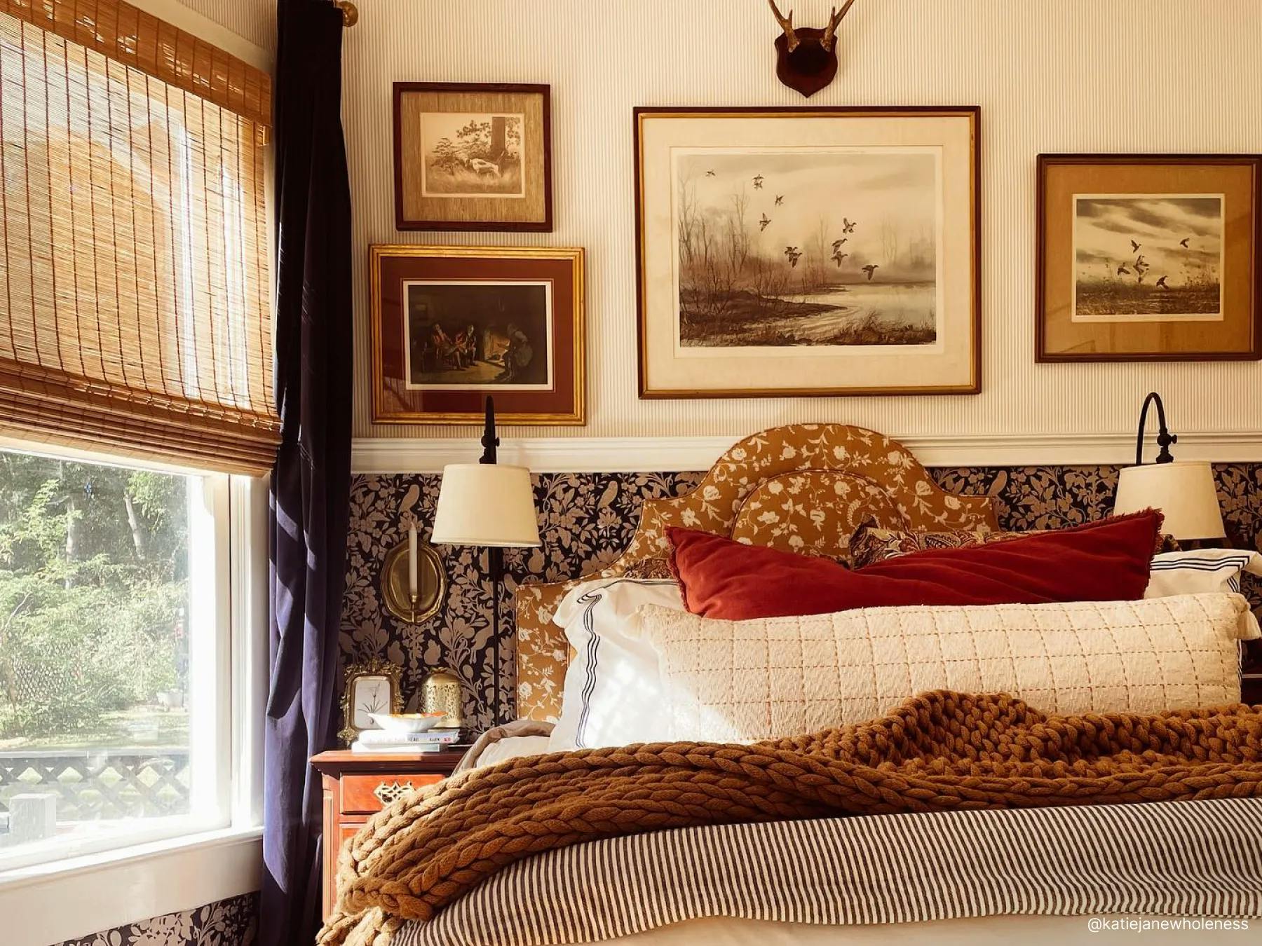 Bedroom with warm-toned bedding and nature-inspired decor. The window is covered with woven wood shades.