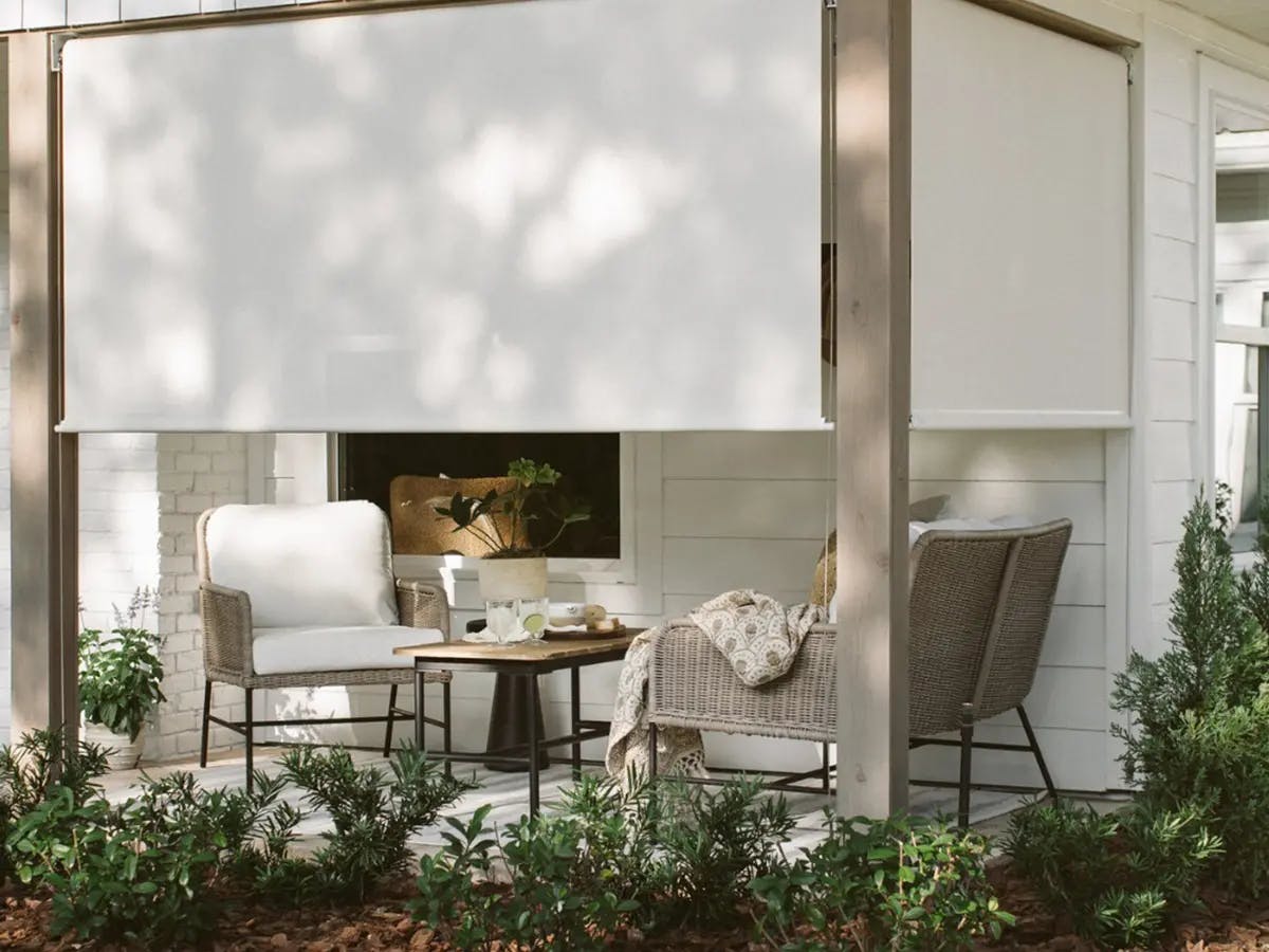 Outdoor patio area with outdoor shades, table and chairs.