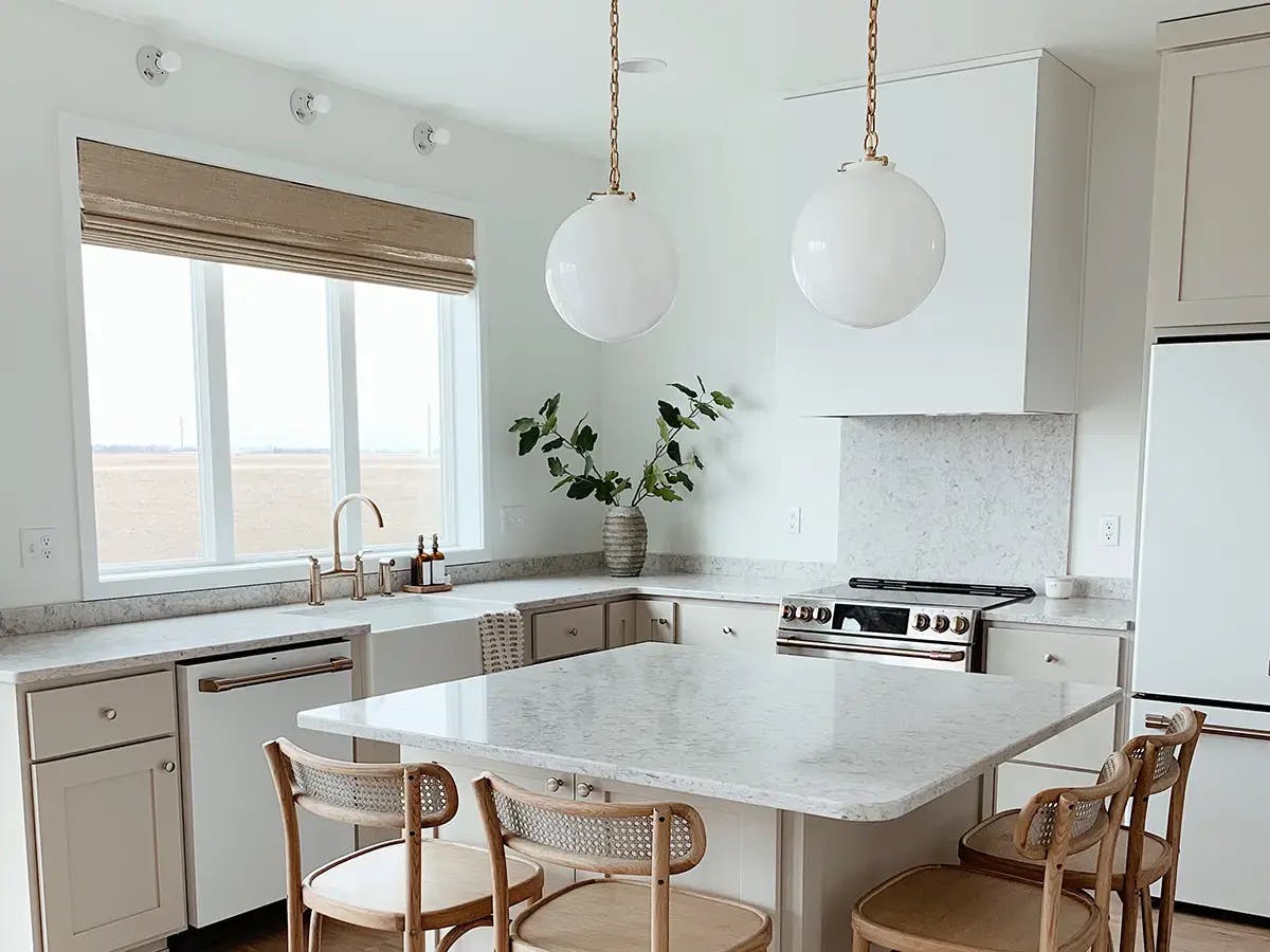 Neutral-colored kitchen with woven wood shades.