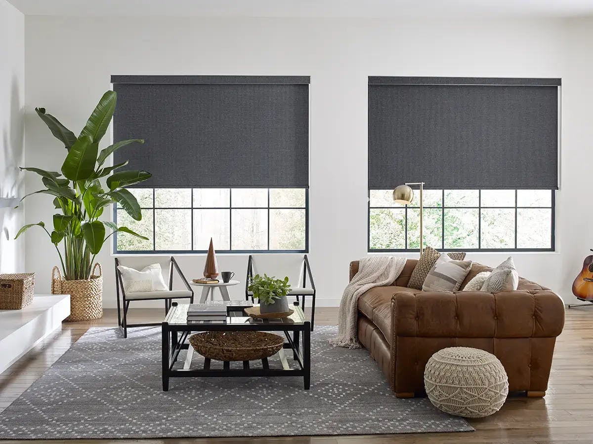 Modern spacious living room with black motorized shades.