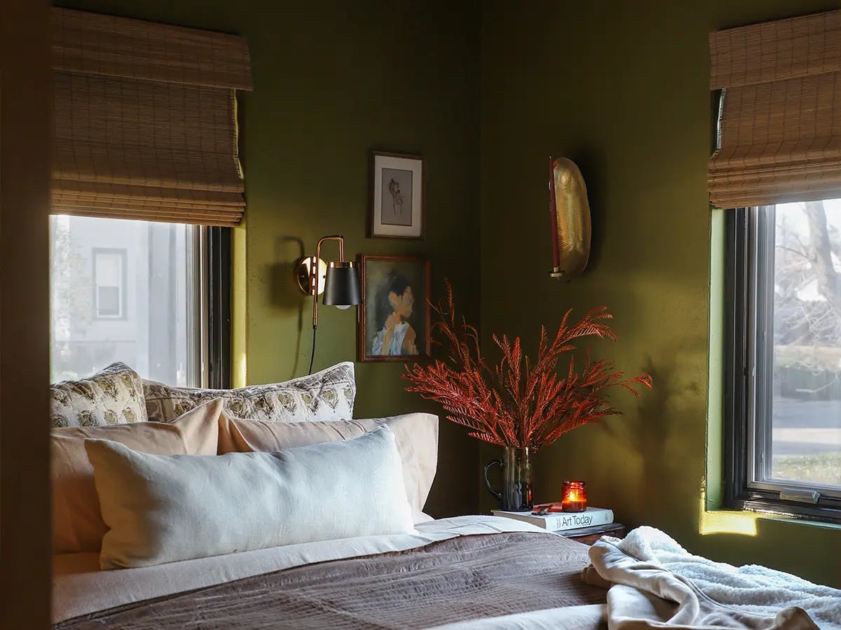 Cozy bedroom with green walls and autumn themed decor.