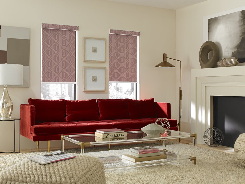Living room with red couch and The Economy Blackout Fabric Roller Shades in Deco Persimmon.