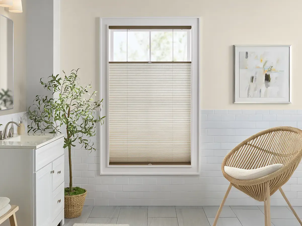 A clean, bright bathroom featuring a top-down bottom-up cellular shade in a cream color.