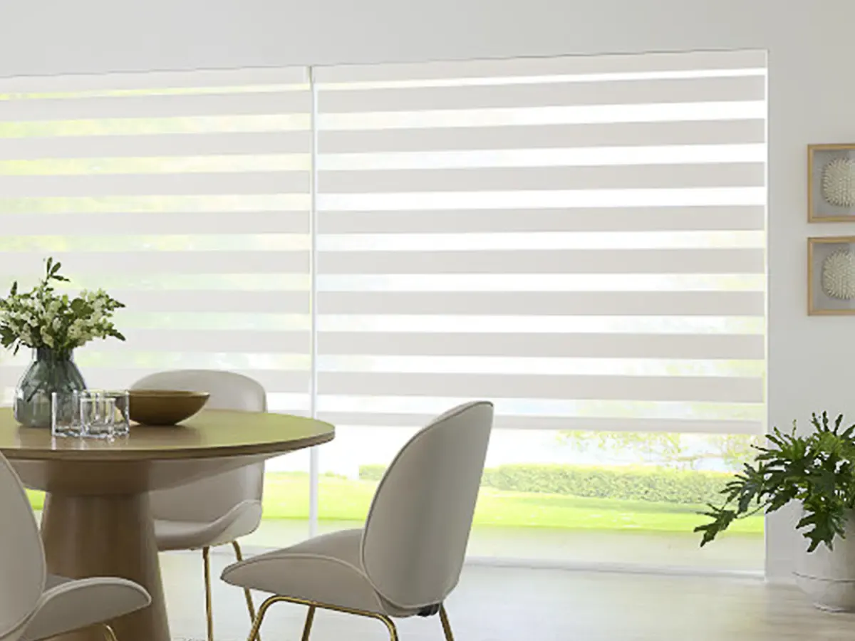 Modern dining room with dual zebra shades filtering natural light through large windows.