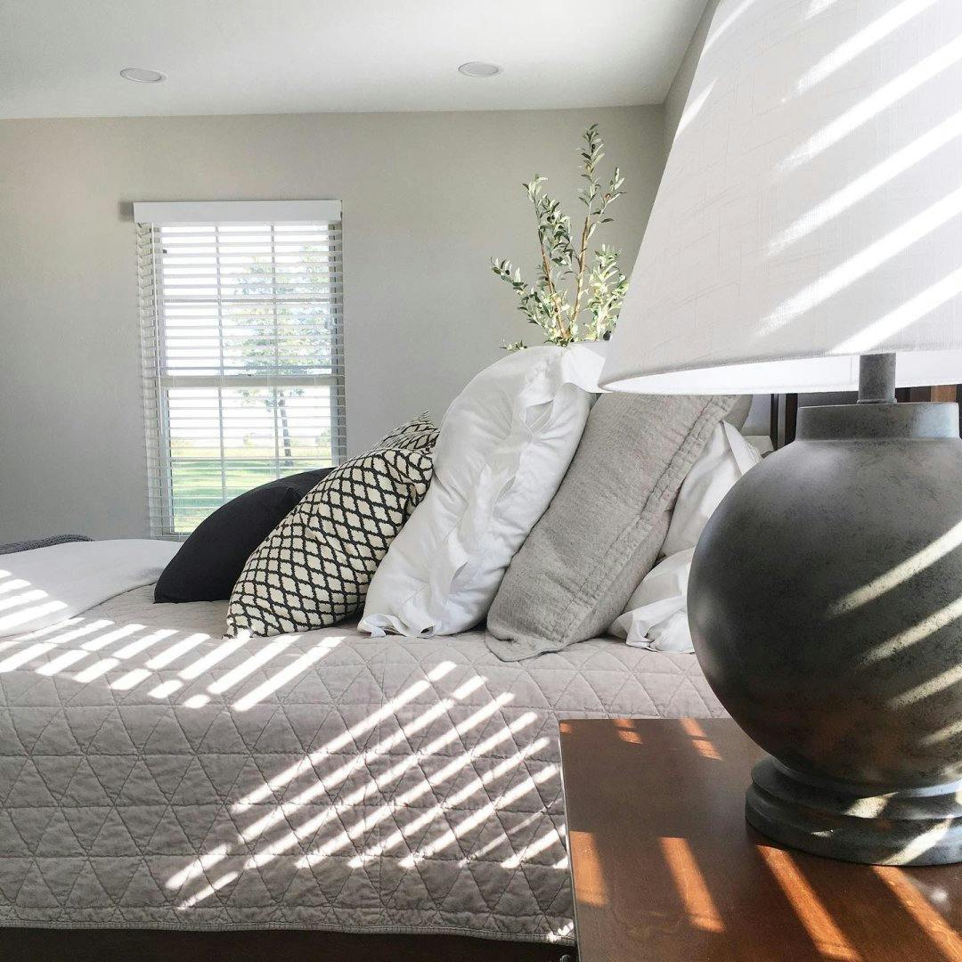 bedroom with white faux wood blinds