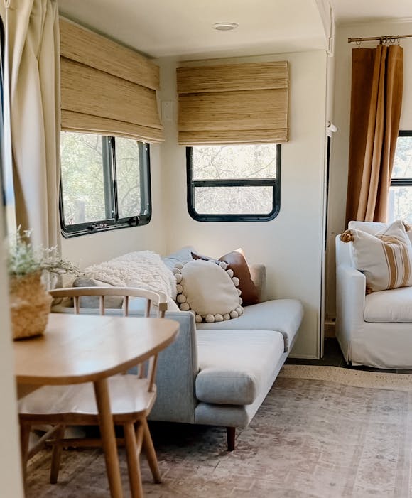 An RV interior with custom woven wood shade window treatments from Blinds.com.