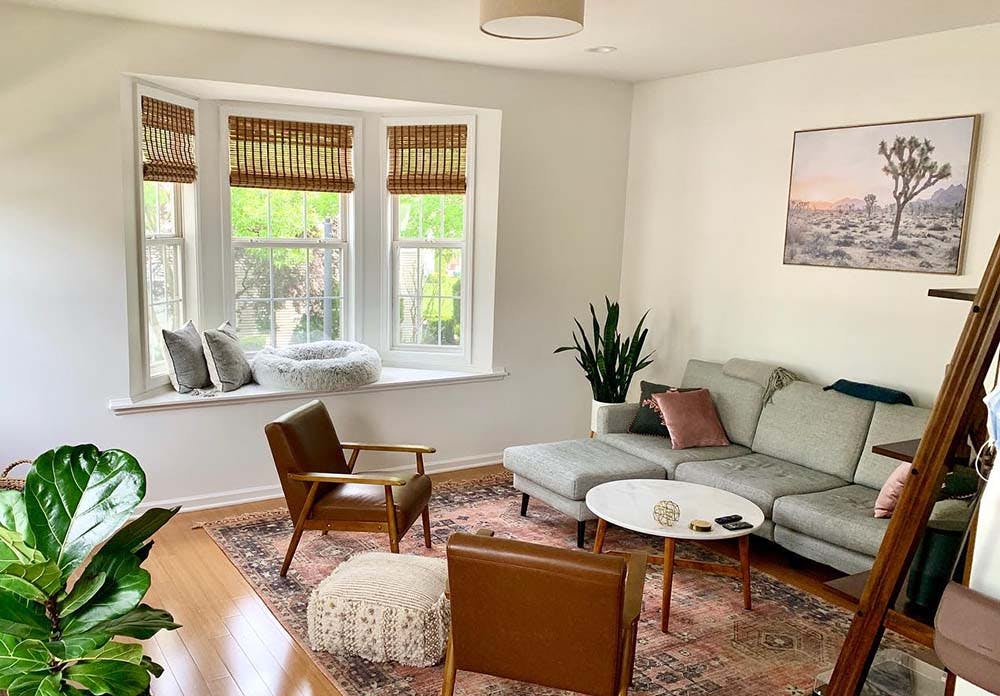 midcentury modern living room with bay window and woven wood shades.