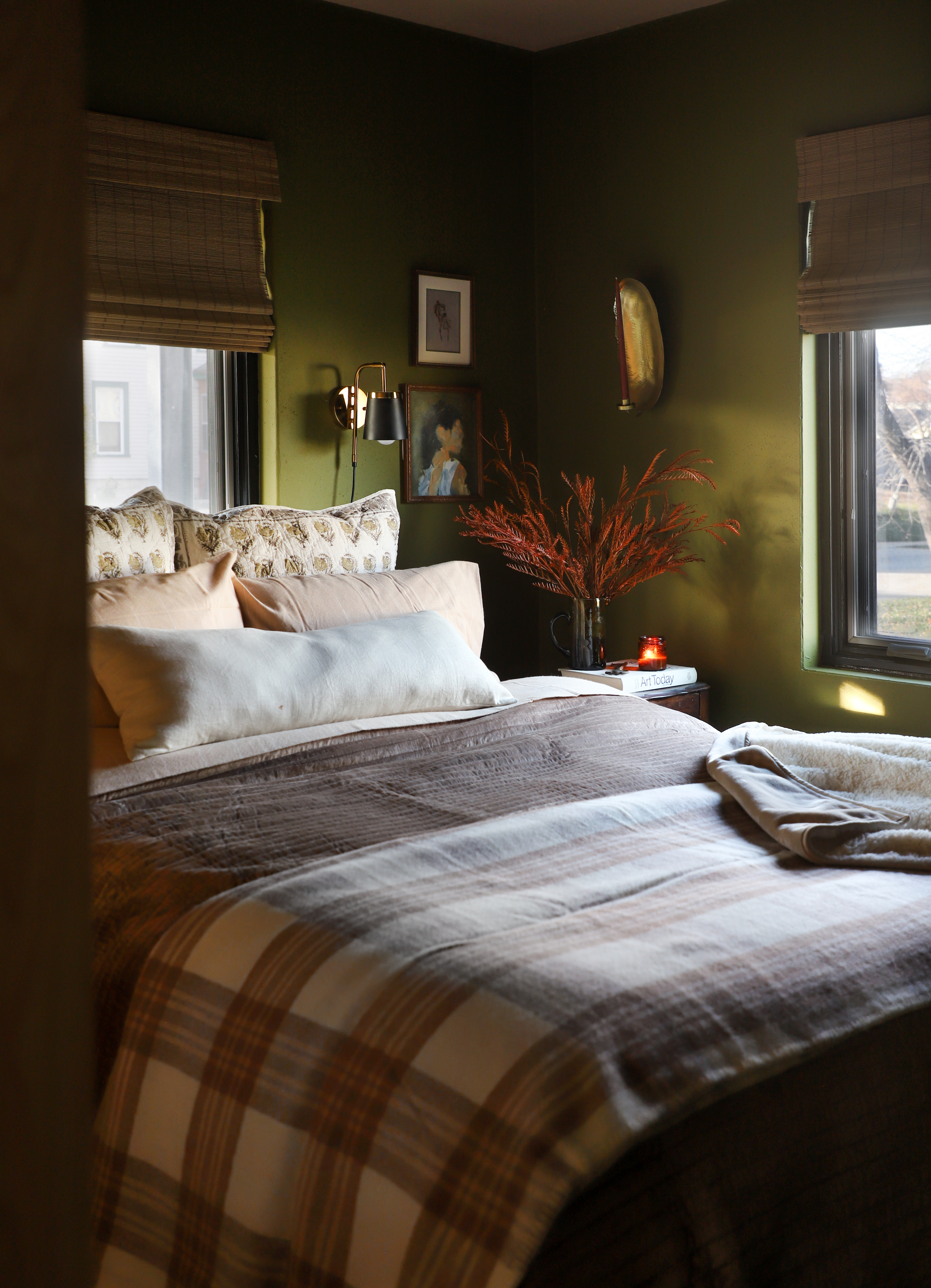 a cozy bedroom with motorized woven wood shades