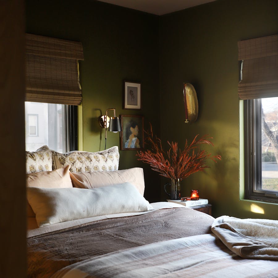 a cozy bedroom with motorized woven wood shades
