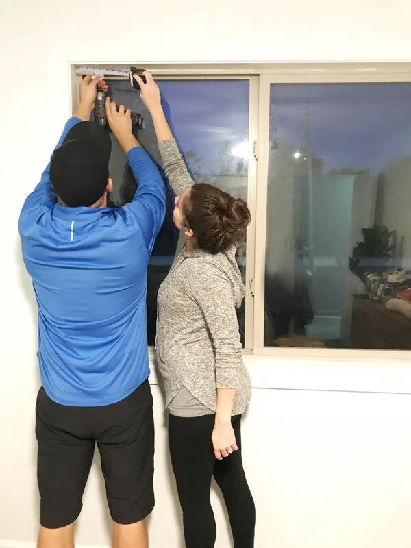 couple installing Blinds.com Roman Shade