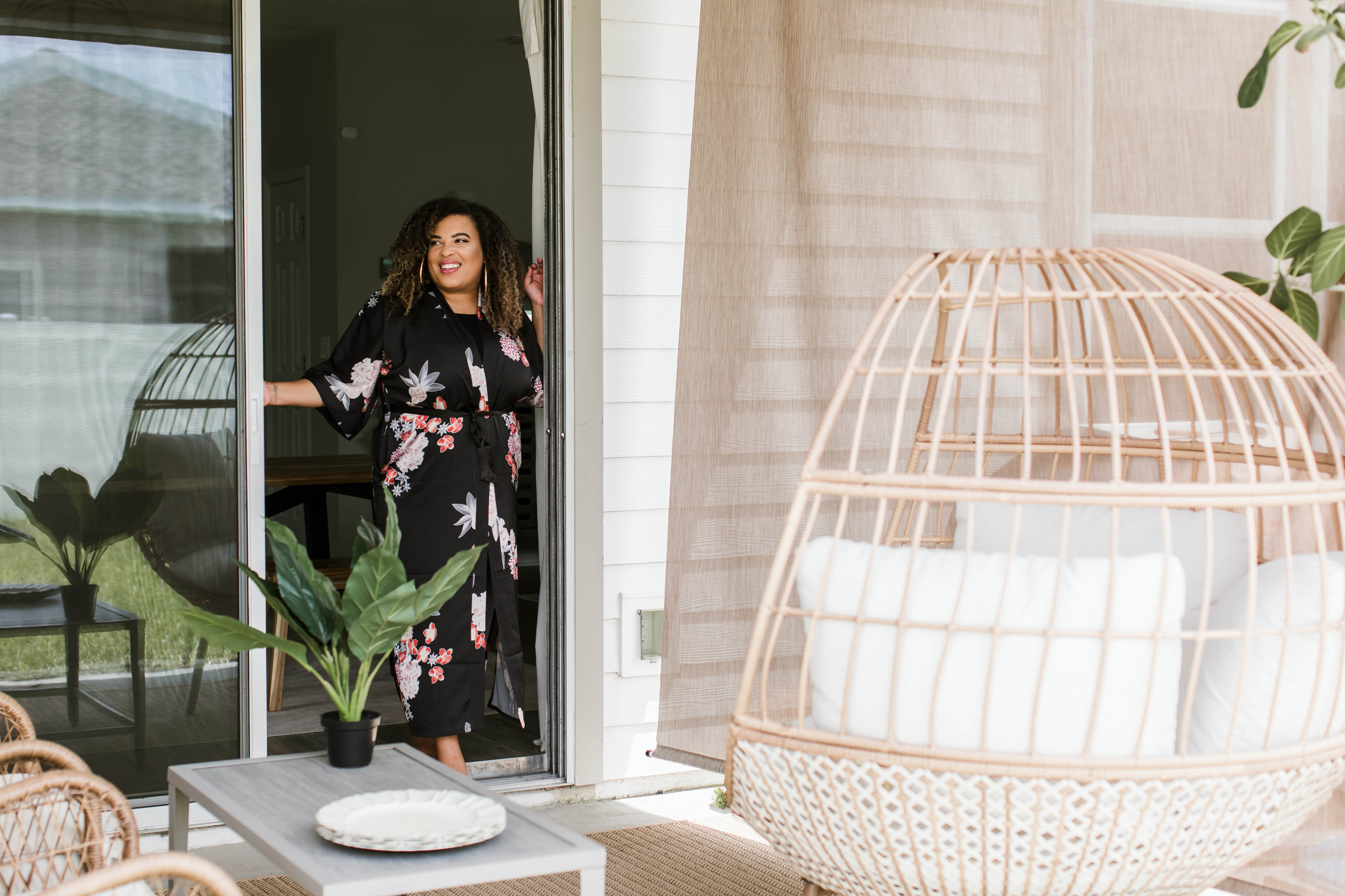 woman standing on porch with outdoor solar shades and patio furniture in the background