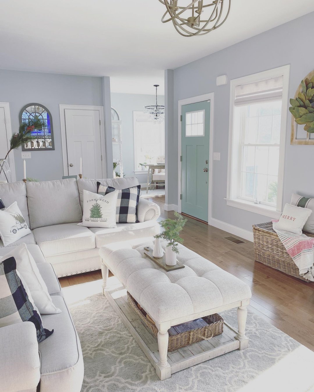 Living room with white furniture with pale blue, grey walls. Cordless woven wood shades are on the window.