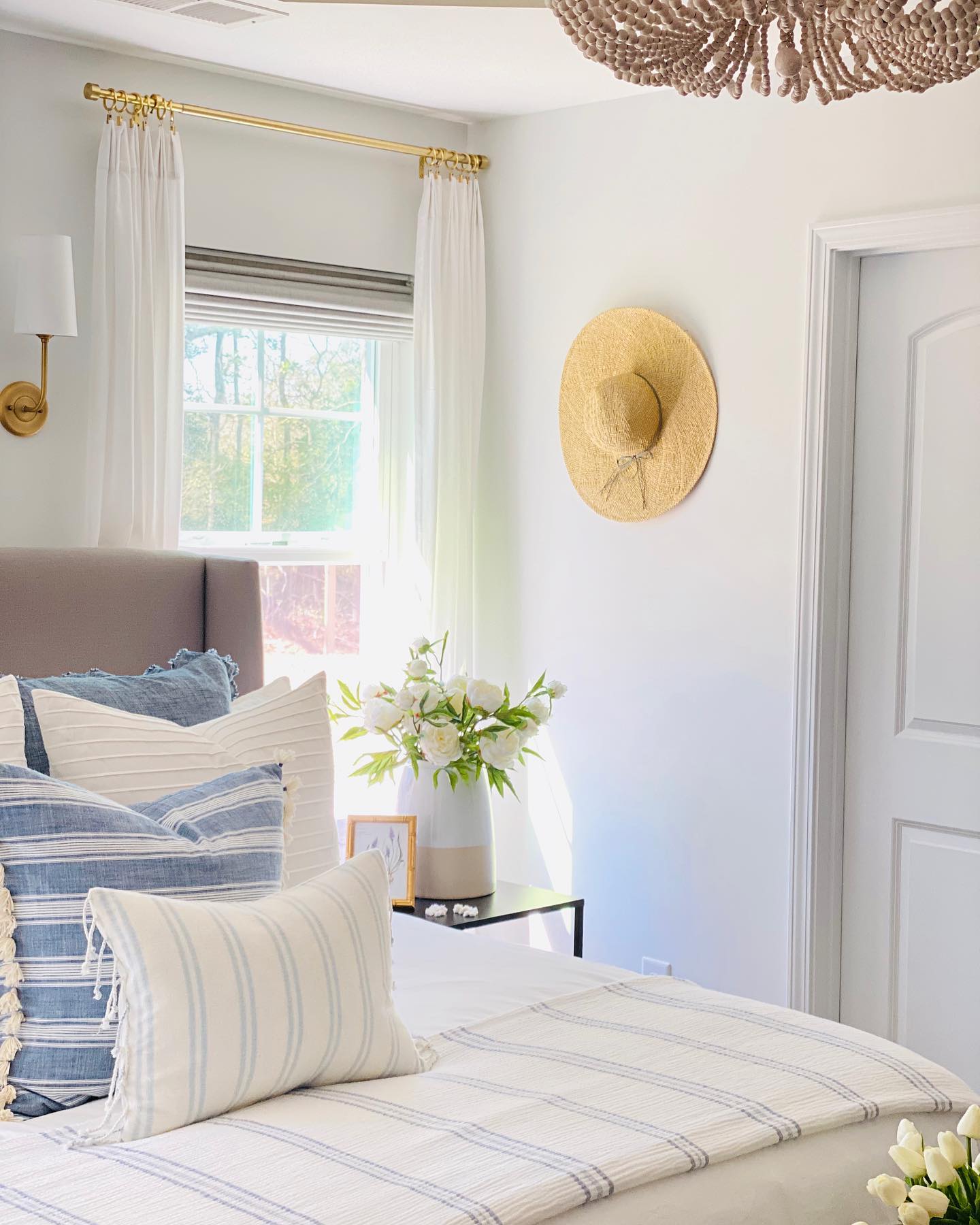 a photo of a bedroom with roman shades and drapery window coverings