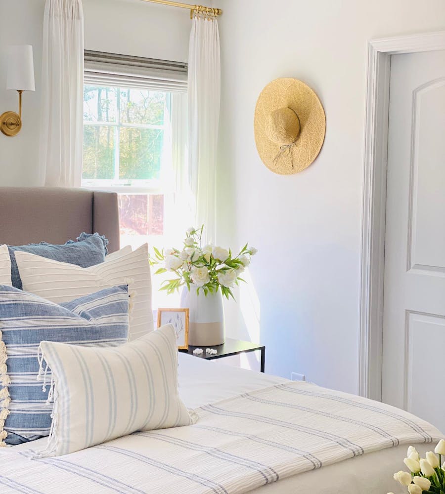 a photo of a bedroom with roman shades and drapery window coverings