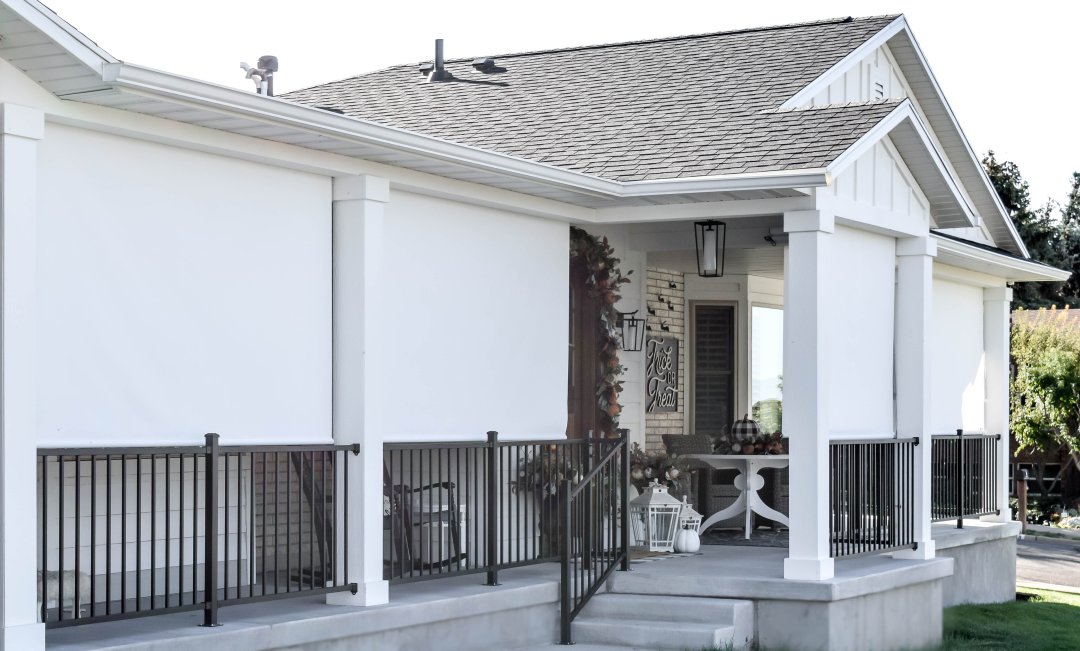 white house with white outdoor solar shades fully shown