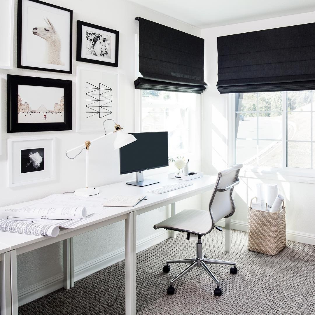 black and white, modern office with gallery wall and black roman shades.