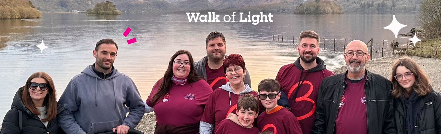 Smiling group in Blood Cancer UK t-shirts in front of a body of water