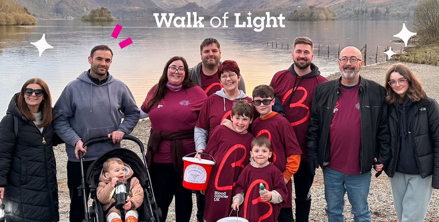 Smiling group in Blood Cancer UK t-shirts in front of a body of water
