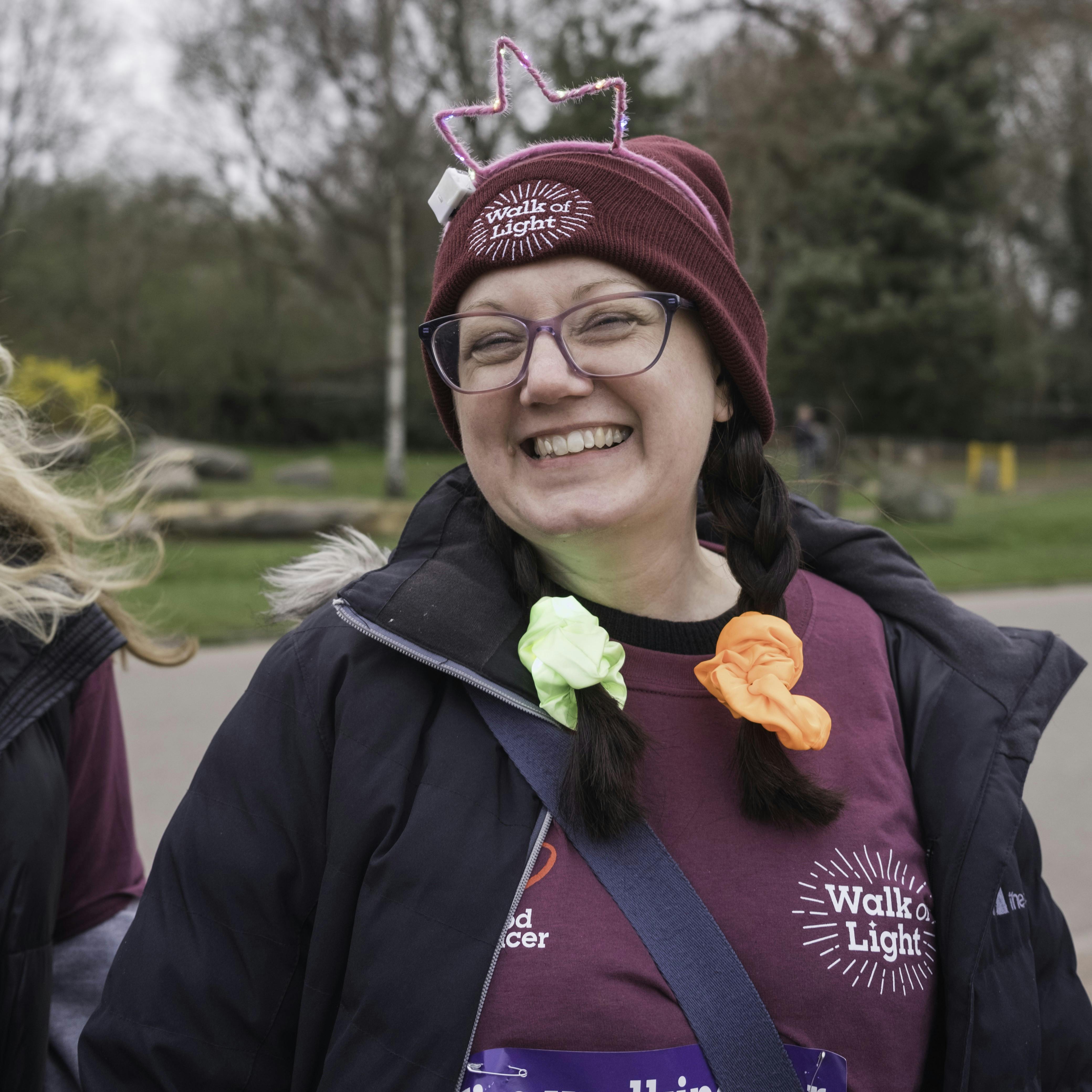 Smiling adult wearing free red Blood Cancer UK beanie