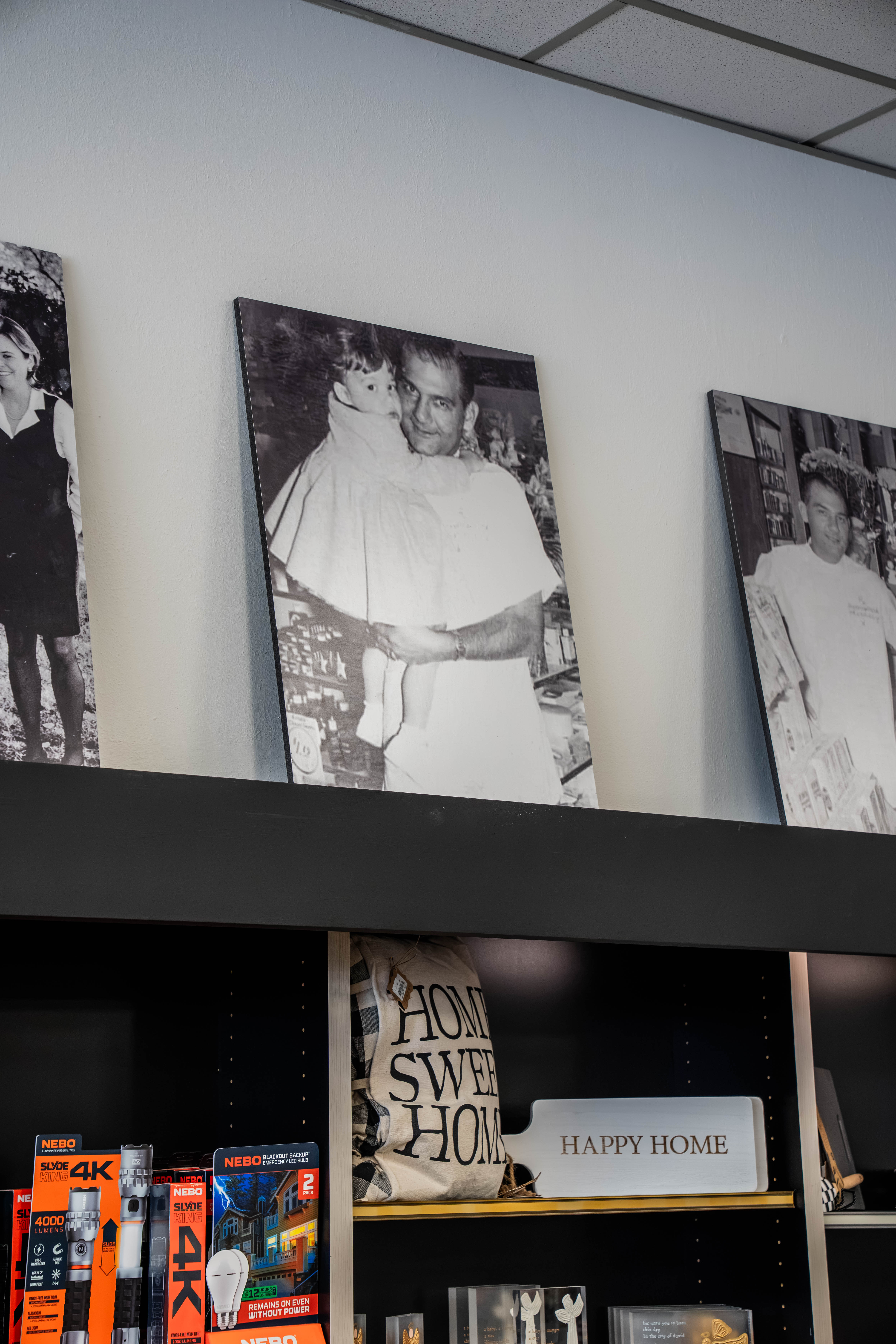 Black-and-white Perrone family photos displayed on a shelf inside the pharmacy.