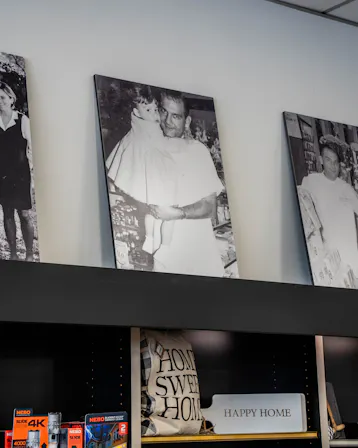 Black-and-white Perrone family photos displayed on a shelf inside the pharmacy.