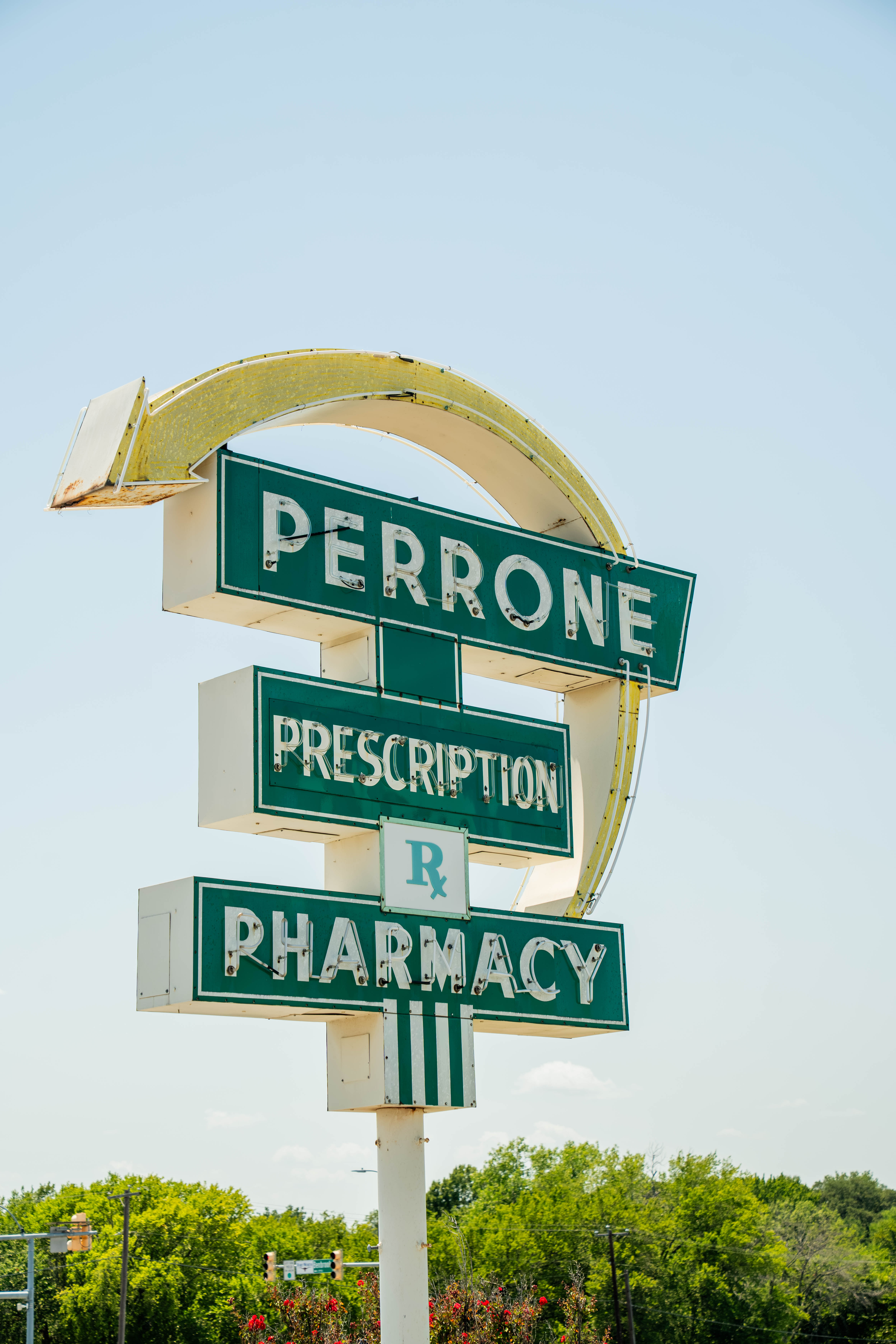 Perrone Pharmacy’s vintage green and white roadside sign reading “Perrone Prescription Pharmacy.”
