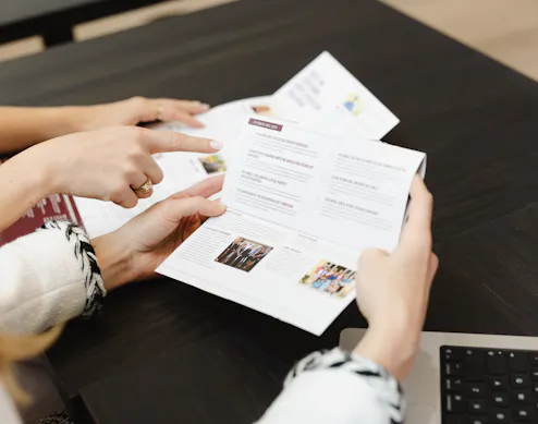 Marketer reviewing a whiteboard with keep, cut, and add columns for annual marketing planning