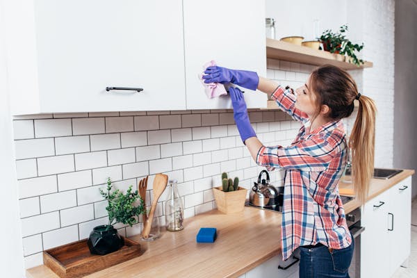 Women cleaning kitchen cupboards