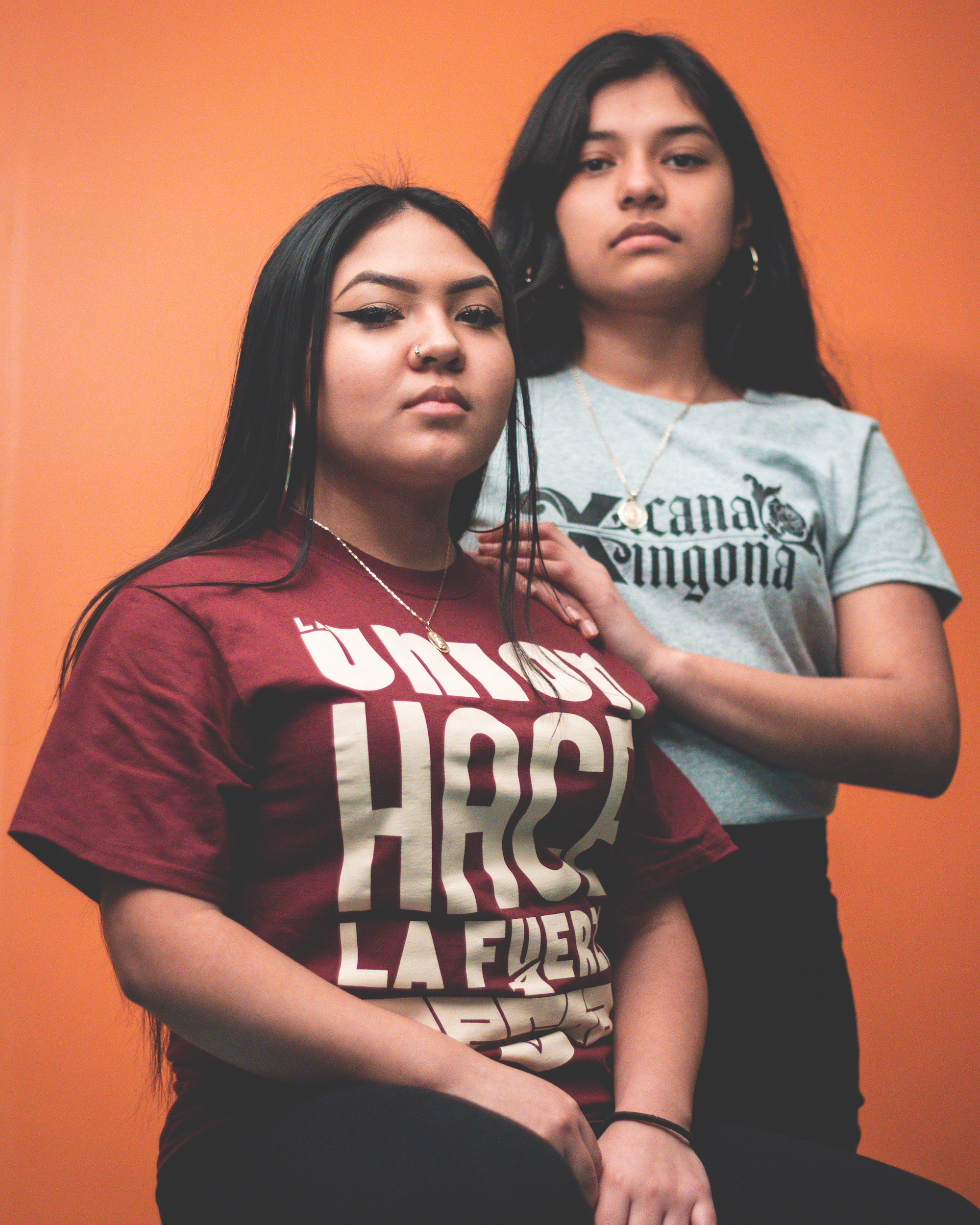 Latinas wearing Chicanx Shop Shirts: La Union Hace La Fuerza and Chicanx Xicana Xingona