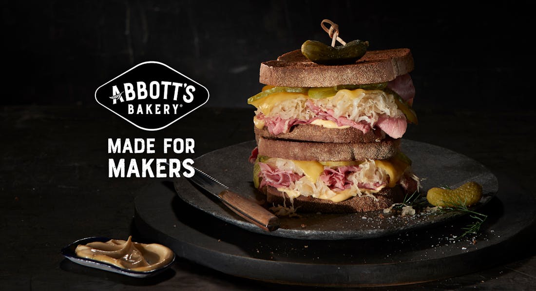 An advertisement for Abbott's Bakery showcasing an appetising image of a toasted ham sandwich on a black plate. A headline reads: "Made for makers".