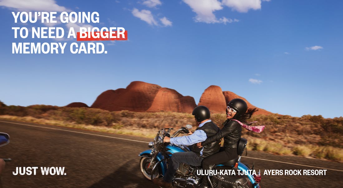 An image of two people on a blue motorcycle riding through the Australian outback with a funny message: "You're going to need a bigger memory card!"