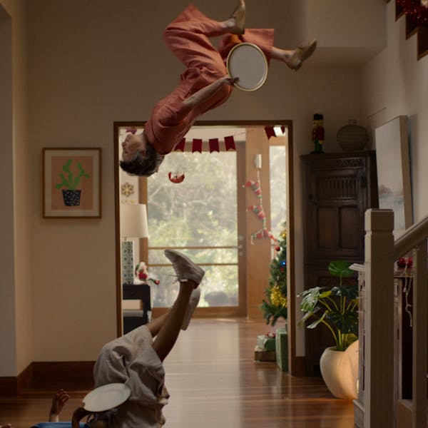 An image of a person holding a plate doing a backflip in a hallway.