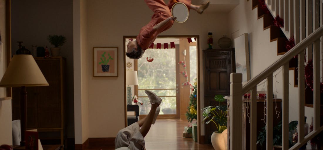 An image of a person holding a plate doing a backflip in a hallway.