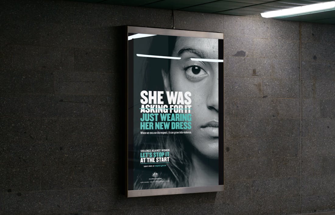 An image of a billboard on a blank concrete wall. The text reads "She was asking for it. Just wearing her new dress". The words "She was asking for it" is crossed out. 
