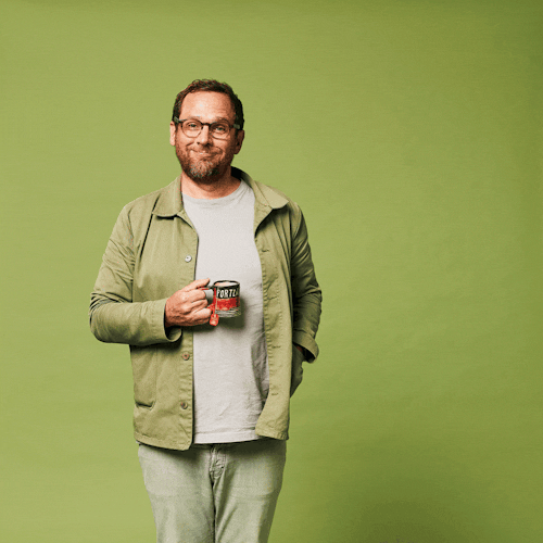 An animated image of a man with short brown hair wearing a green shirt, he is drinking tea from a mug.