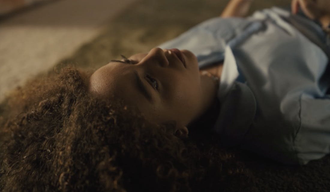 An image of a woman lying on the floor looking at the ceiling.