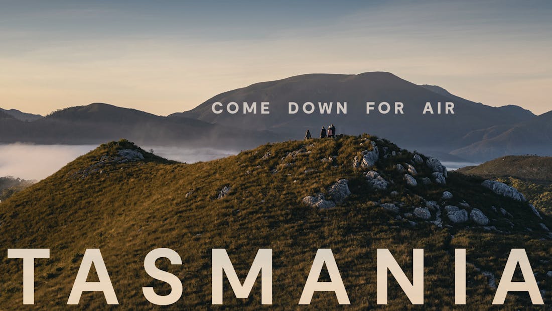 A billboard design showcasing an image of people standing on a hill looking over a stunning landscape. A headline reads: "Come down for air".