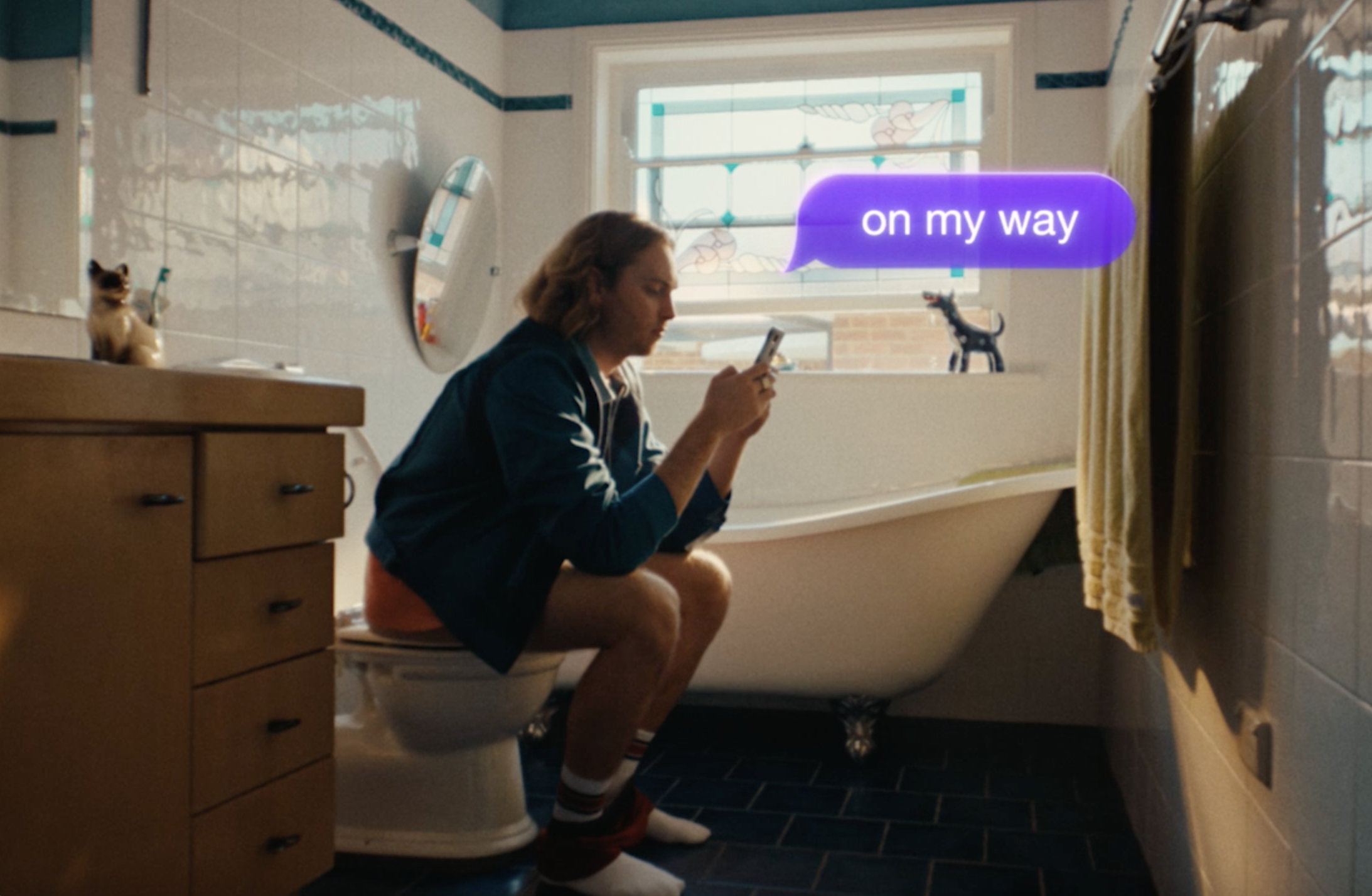A man sitting on the toilet sending the text "on my way"