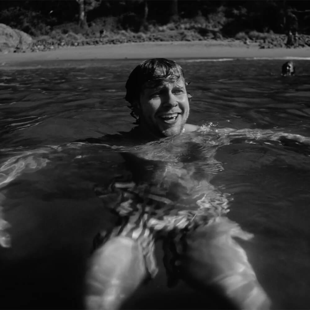 Man swimming in the ocean with a smile