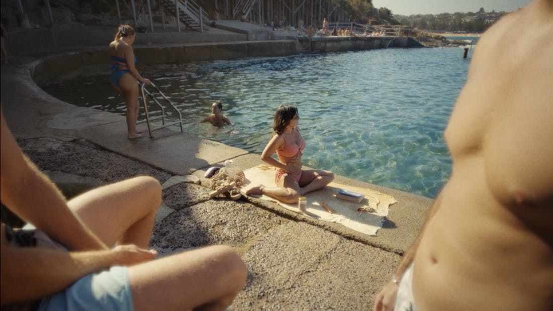 Woman applying sunscreen on her stomach at the beach
