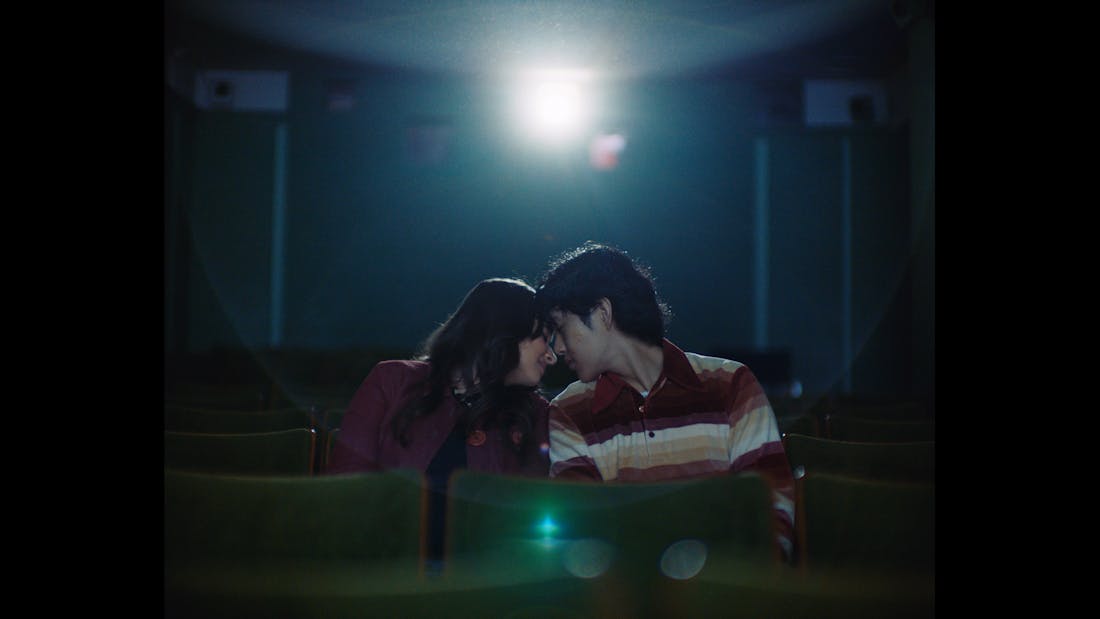 A couple leaning in to hold each other in a cinema
